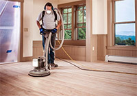 man using wood belt sander